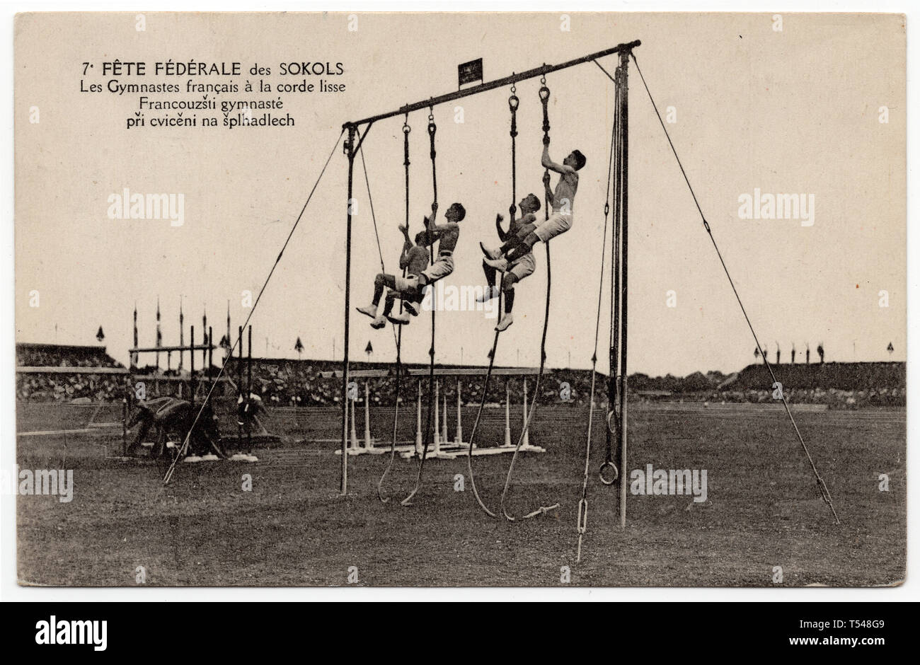 French gymnasts climbing up the rope during the 7th Sokol international mass gymnastics festival (VII. všesokolský slet) in Prague, Czechoslovakia, in June 1920. Black and white photograph by an unknown photographer published on the Czechoslovak vintage postcard issued in 1920. Courtesy of the Azoor Postcard Collection. Stock Photo