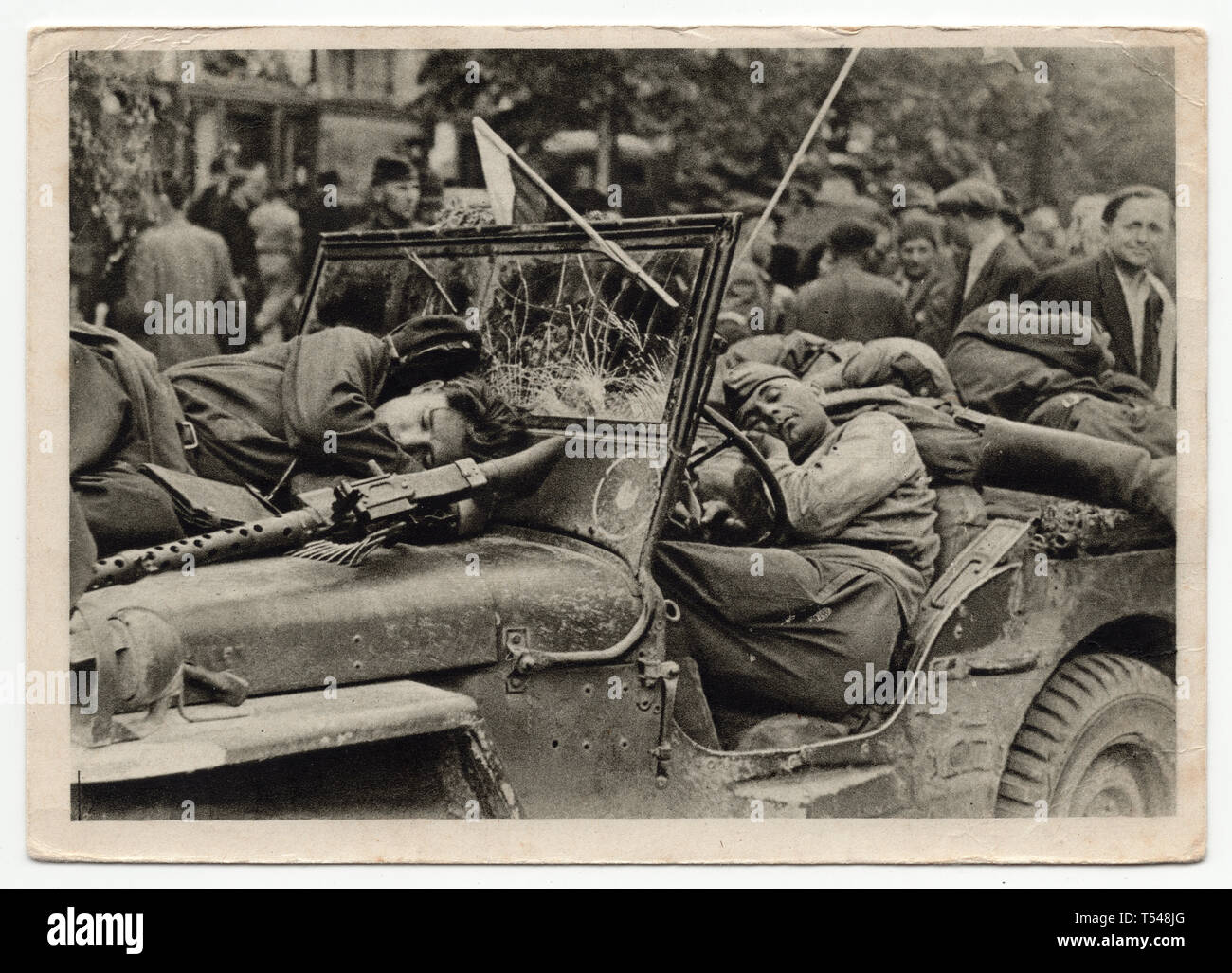 Red Army soldiers sleep in and on the US military jeep Willys MB in Prague, Czechoslovakia, on 9 May 1945. Black and white photograph by Czech photographer Zdeněk Tmej taken in May 1945 and issued in the Czechoslovak vintage postcard in 1945. Courtesy of the Azoor Postcard Collection. Stock Photo