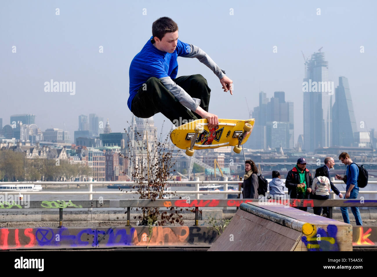 Skateboarder on Waterloo Bridge against a backdrop of the City of London. Stock Photo