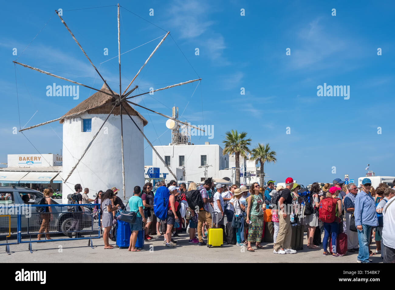 Paros, Greece - June 5, 2018: Unidentified tourists waiting in line to ferry boat with a Traditional cycladic windmill at background on Paros island,  Stock Photo