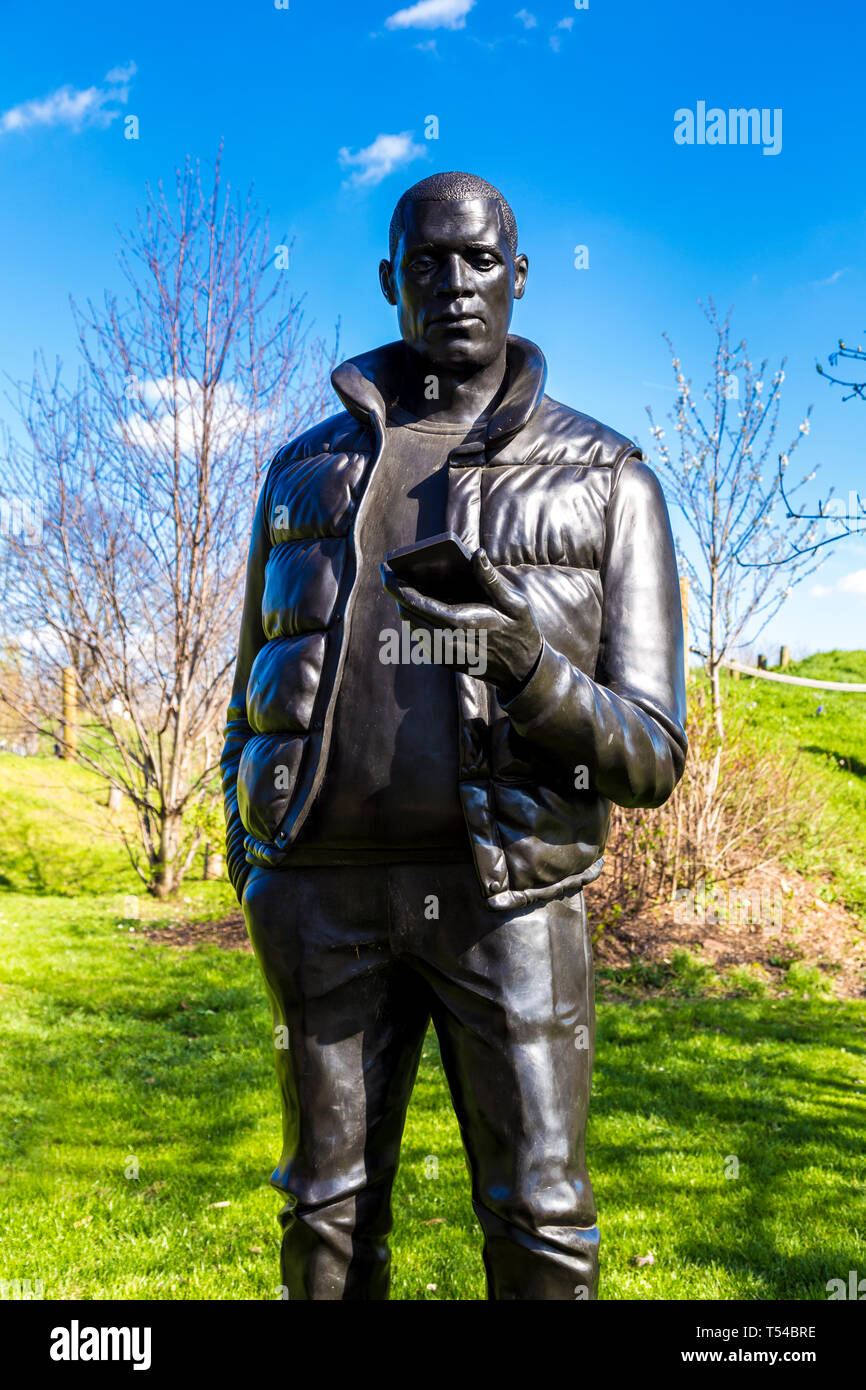 Sculpture of man holding a mobile phone by Thomas J Price, 'Network', 2013, in Three Mills part of The Line Sculpture Trail art walk, London, UK Stock Photo