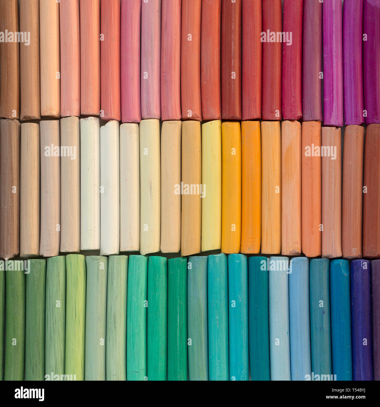 Rainbow pastel crayons in rows as background. Square image Stock Photo