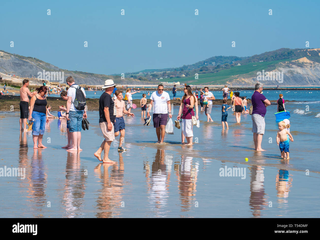 Lyme Regis, Dorset, UK. 20th April 2019. UK Weather: Beachgoers cool down in the sea at the seaside resort of Lyme Regis on a scorching hot Easter Saturday afternoon,  Families enjoy paddling in the sea. Credit: Celia McMahon/Alamy Live News. Stock Photo