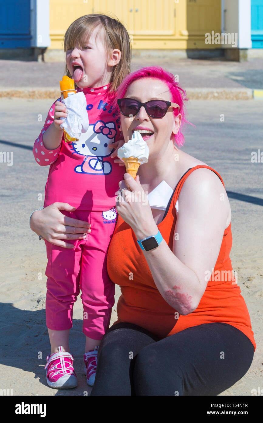 Bournemouth, Dorset, UK. 21st Apr 2019. UK weather: the heatwave continues with hot and sunny weather, as beachgoers head to the seaside to enjoy the heat and sunshine at Bournemouth beaches for the Easter holidays - mid morning and already beaches are getting packed, as sunseekers get there early to get their space. Debbie and Betty May enjoy an ice cream and ice lolly. Credit: Carolyn Jenkins/Alamy Live News Stock Photo