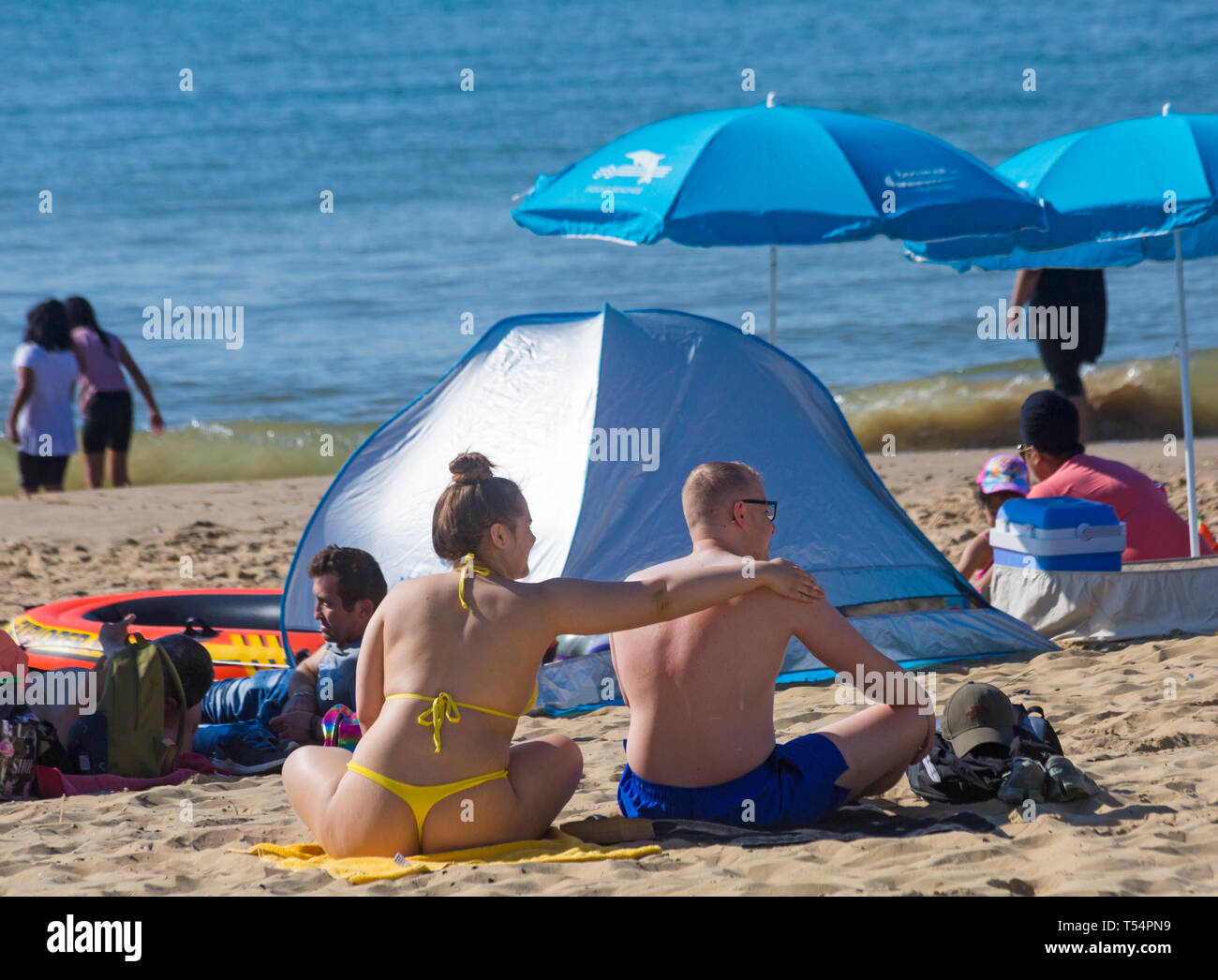 https://c8.alamy.com/comp/T54PN9/bournemouth-dorset-uk-21st-apr-2019-uk-weather-the-heatwave-continues-with-hot-and-sunny-weather-as-beachgoers-head-to-the-seaside-to-enjoy-the-heat-and-sunshine-at-bournemouth-beaches-for-the-easter-holidays-mid-morning-and-already-beaches-are-getting-packed-as-sunseekers-get-there-early-to-get-their-space-young-woman-wearing-thong-bikini-rubbing-in-sun-tan-lotion-on-mans-back-credit-carolyn-jenkinsalamy-live-news-T54PN9.jpg