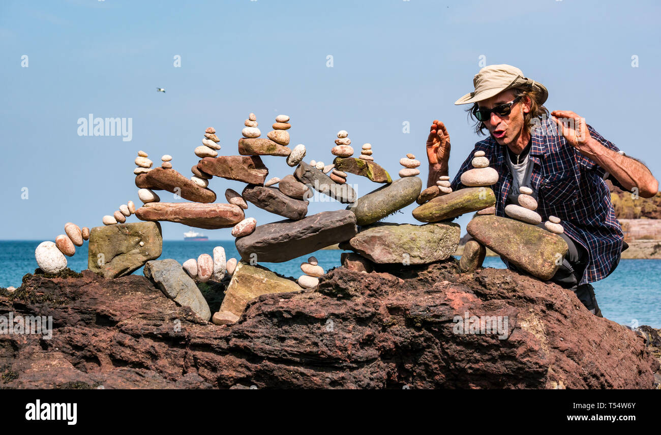 Dunbar, East Lothian, Scotland, UK. 21st Apr 2019. European stone stacking championship: Pedro Duran, from Spain and overall winner of last year's competition balances stones in the artistic competition, giving competitors 3 hours to create anything from stones or found objects  competition at Eye Cave beach Stock Photo