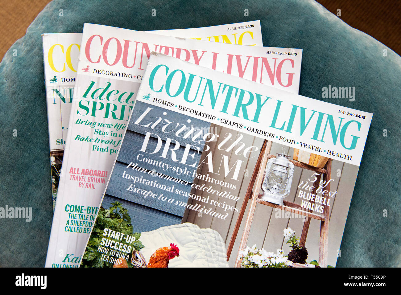 Three Country Living magazines on velvet cushion Stock Photo