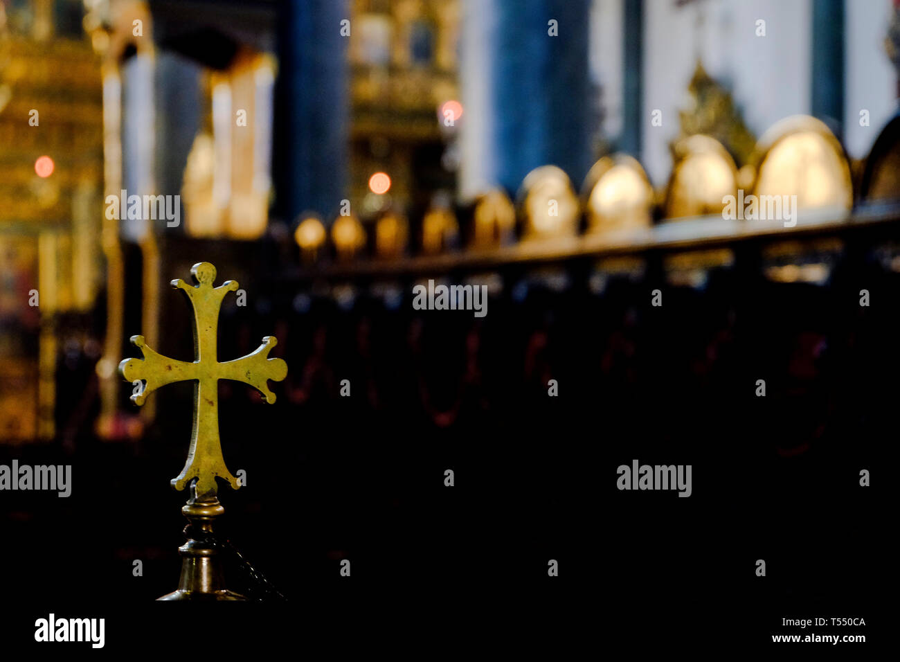 Metallic rounded golden cross inside a church Stock Photo