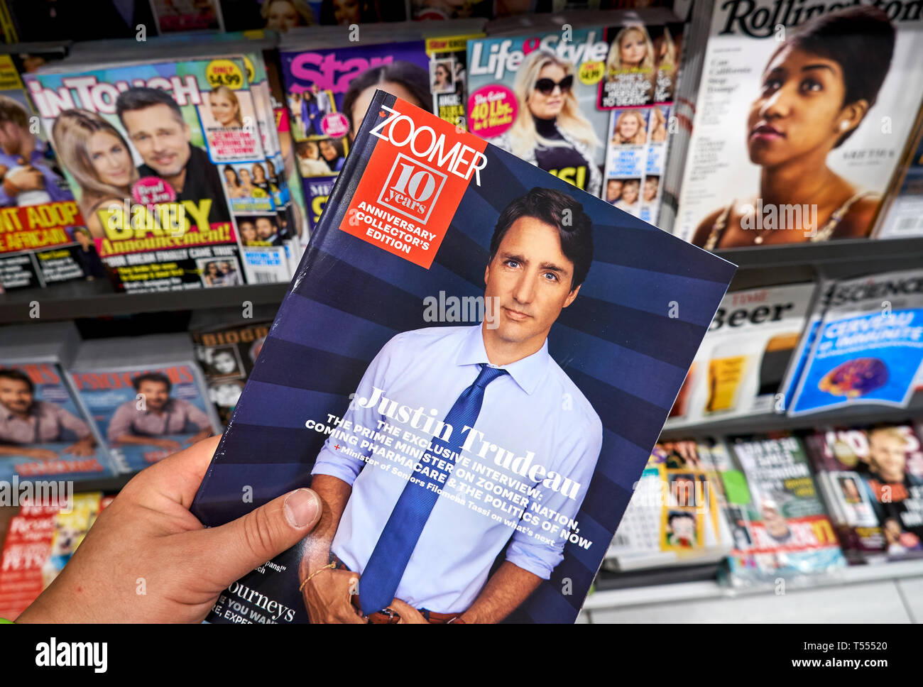 MONTREAL, CANADA - OCTOBER 9, 2018: Zoomer magazine with Canadian Prime Minister Justin Trudeau in a hand over a stack of magazines. Stock Photo