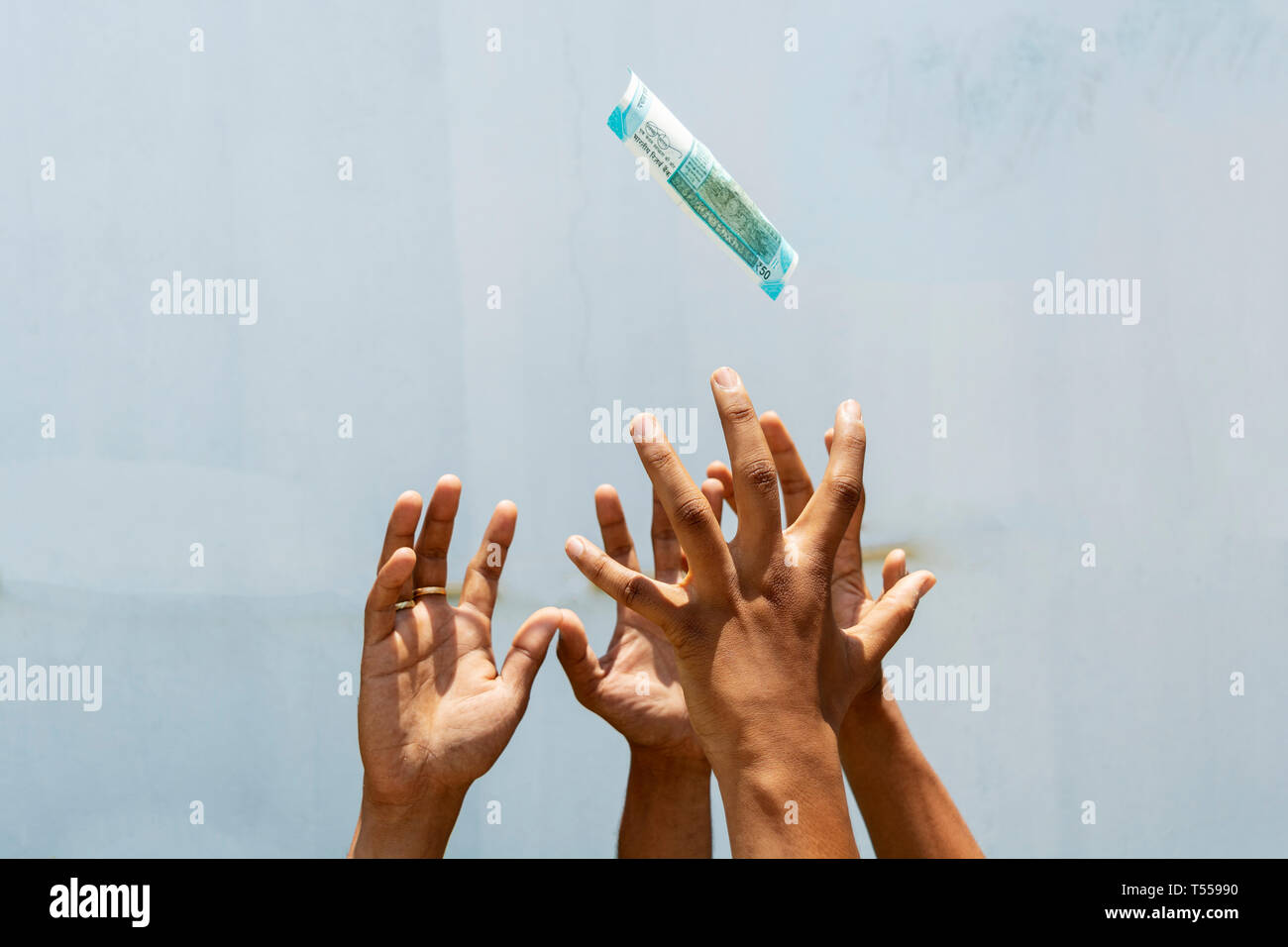 Hands trying to get or catch the flying money on isolated background. Stock Photo
