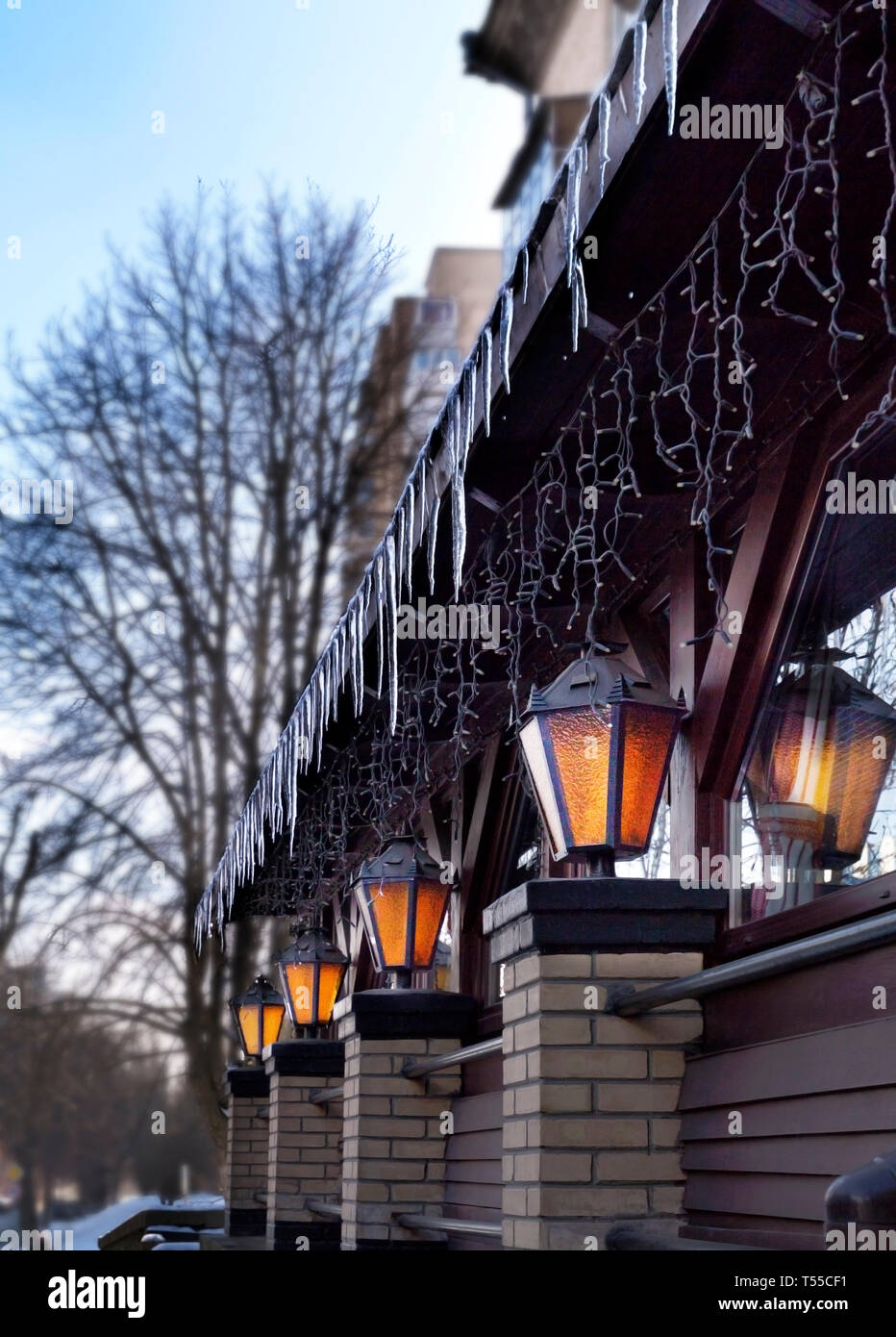 Four old street lamps shine near the restaurant windows in the open air