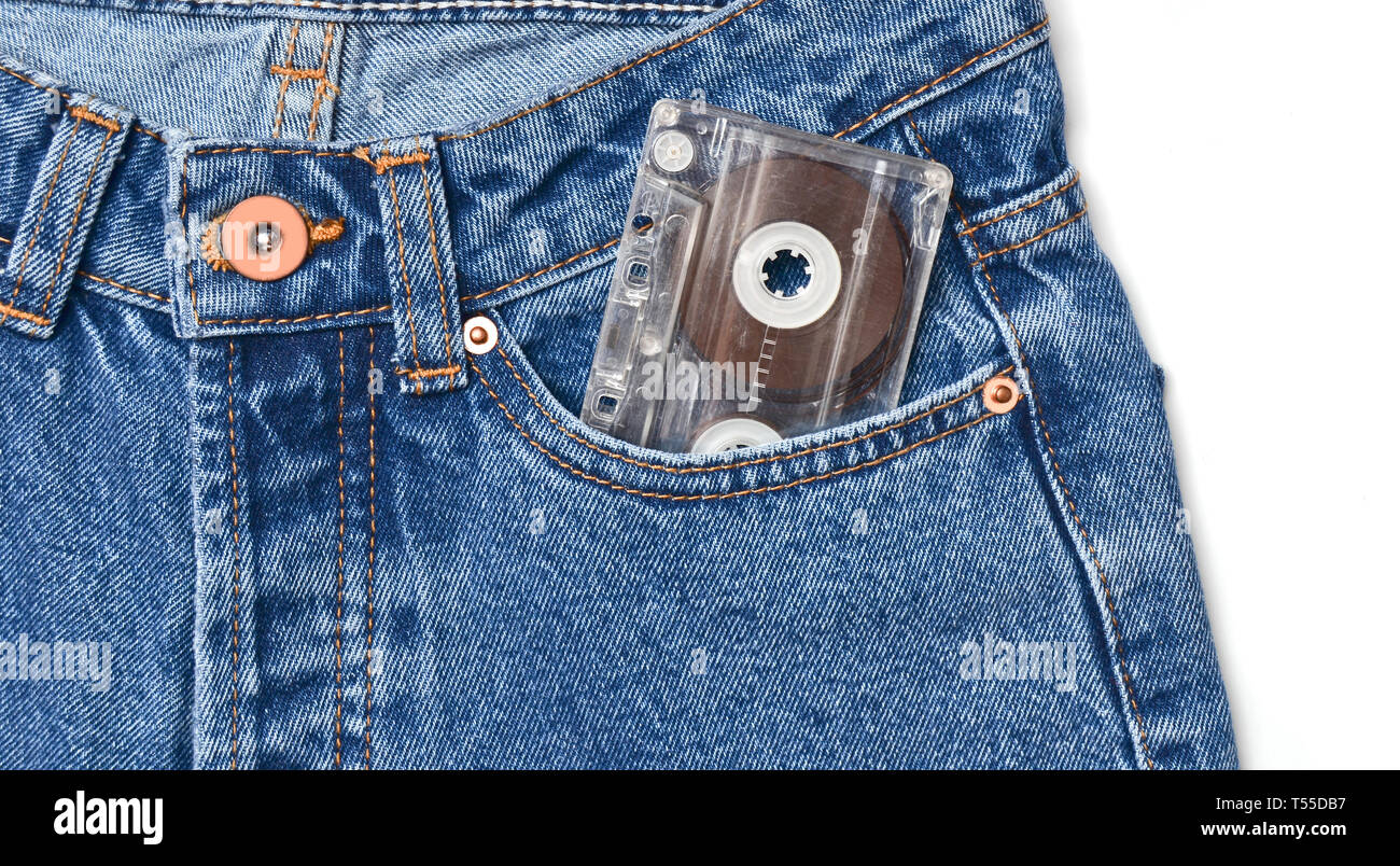 Audio cassette in a pocket of oldfashioned blue jeans isolated on a