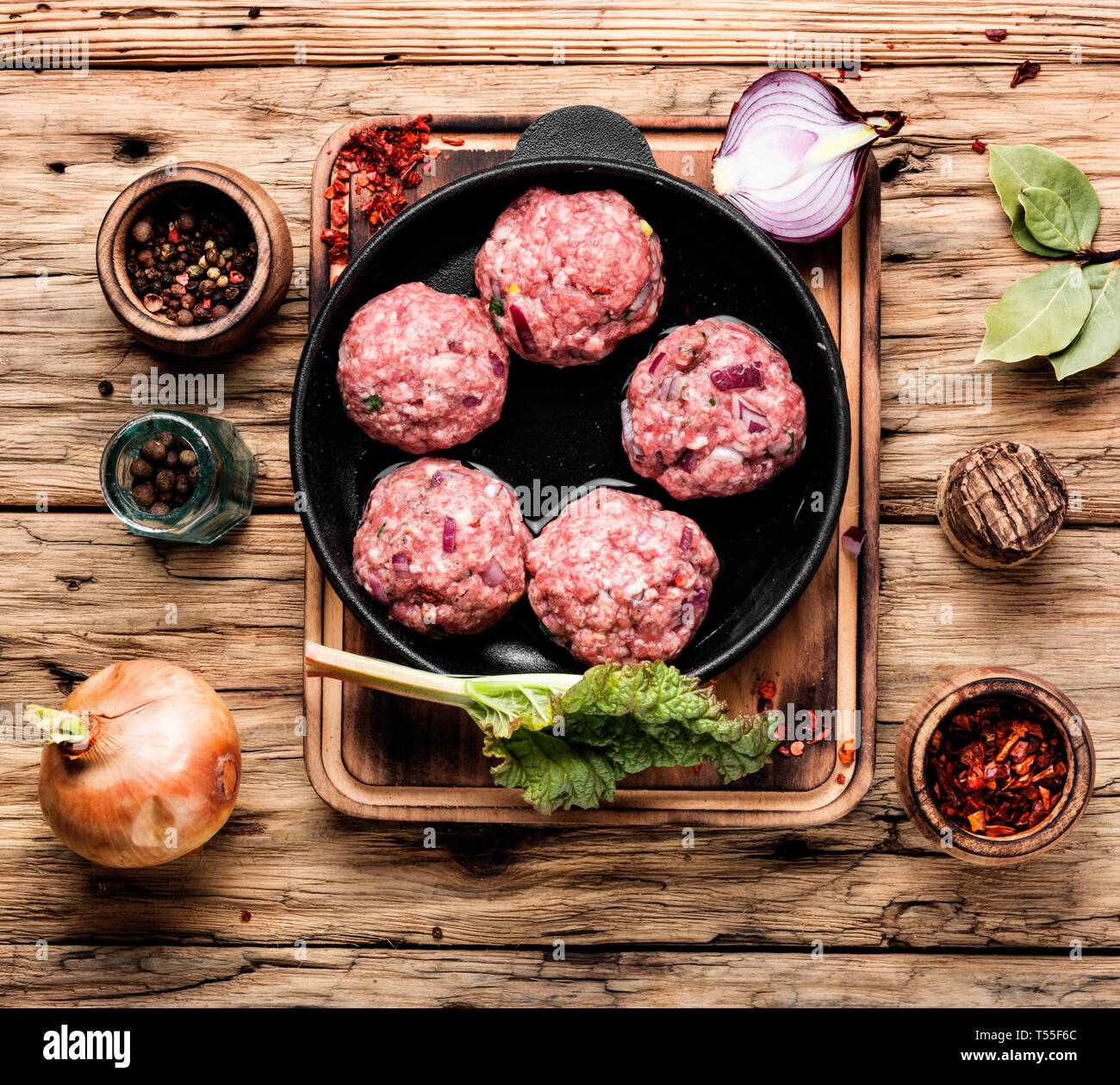 Meat balls from raw beef forcemeat in iron cast pan.Meatballs