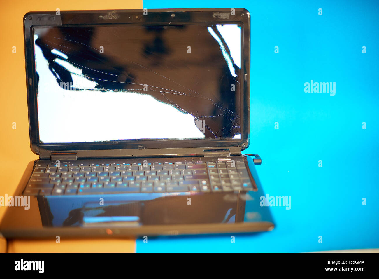 a broken laptop screen on a colorful background Stock Photo