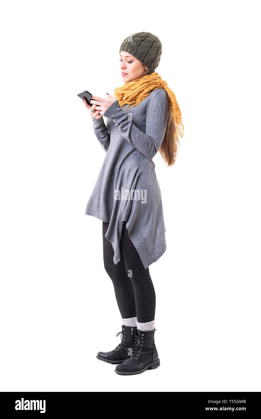 Cool young unique style woman in winter clothes reading message on