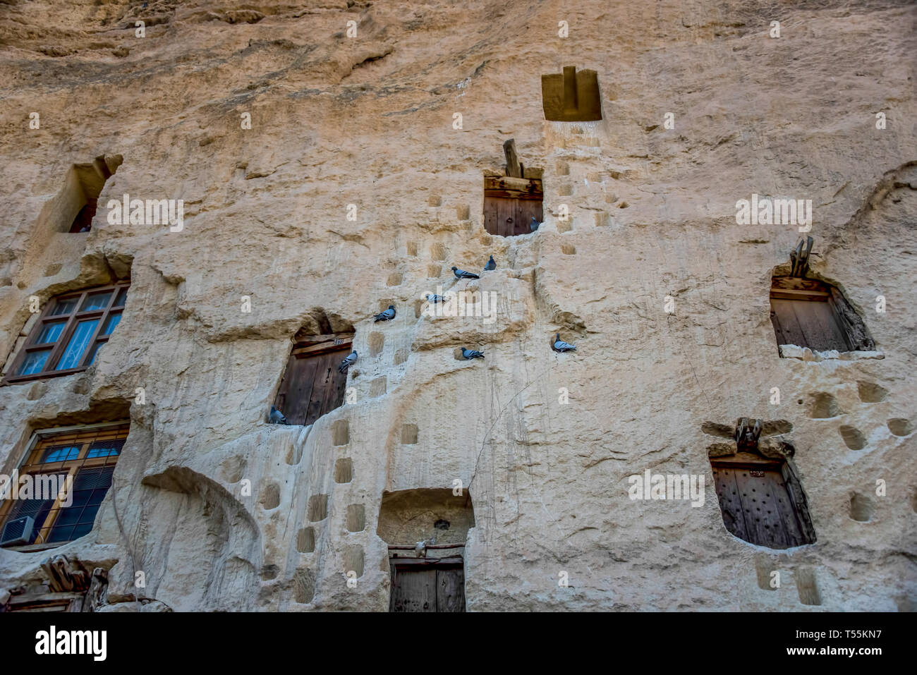 An ancient tradition, naturally cool stone carved warehouses along with many pigeon lofts for manure on a limestone cliff in Ermenek, Turkey Stock Photo