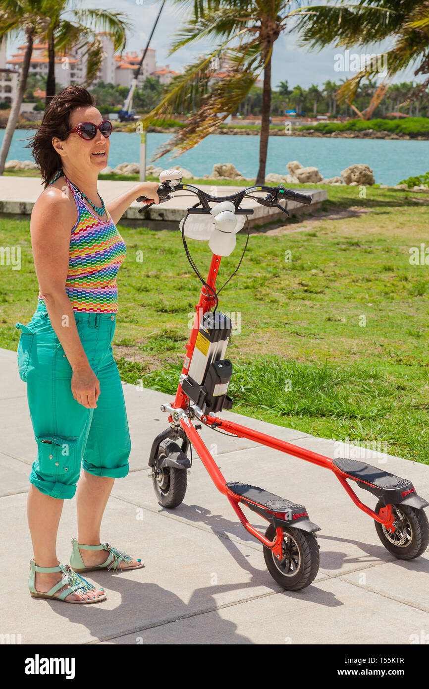 Woman on an electric tricycle in Miami Stock Photo