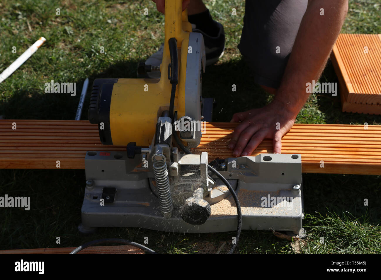 A worker saw wood with a chop saw Stock Photo Alamy