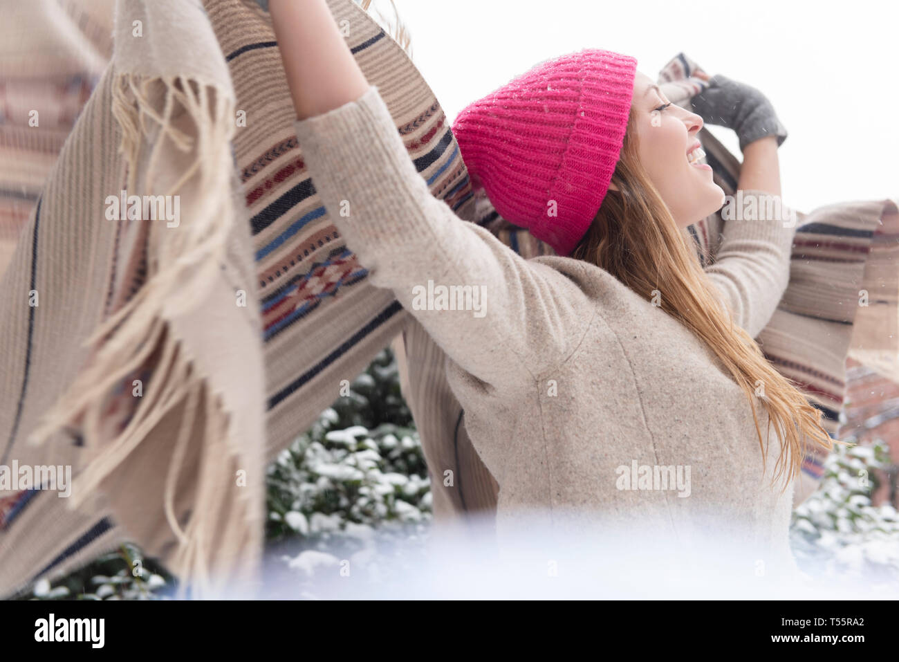 Young woman holding shawl aloft in snow Stock Photo