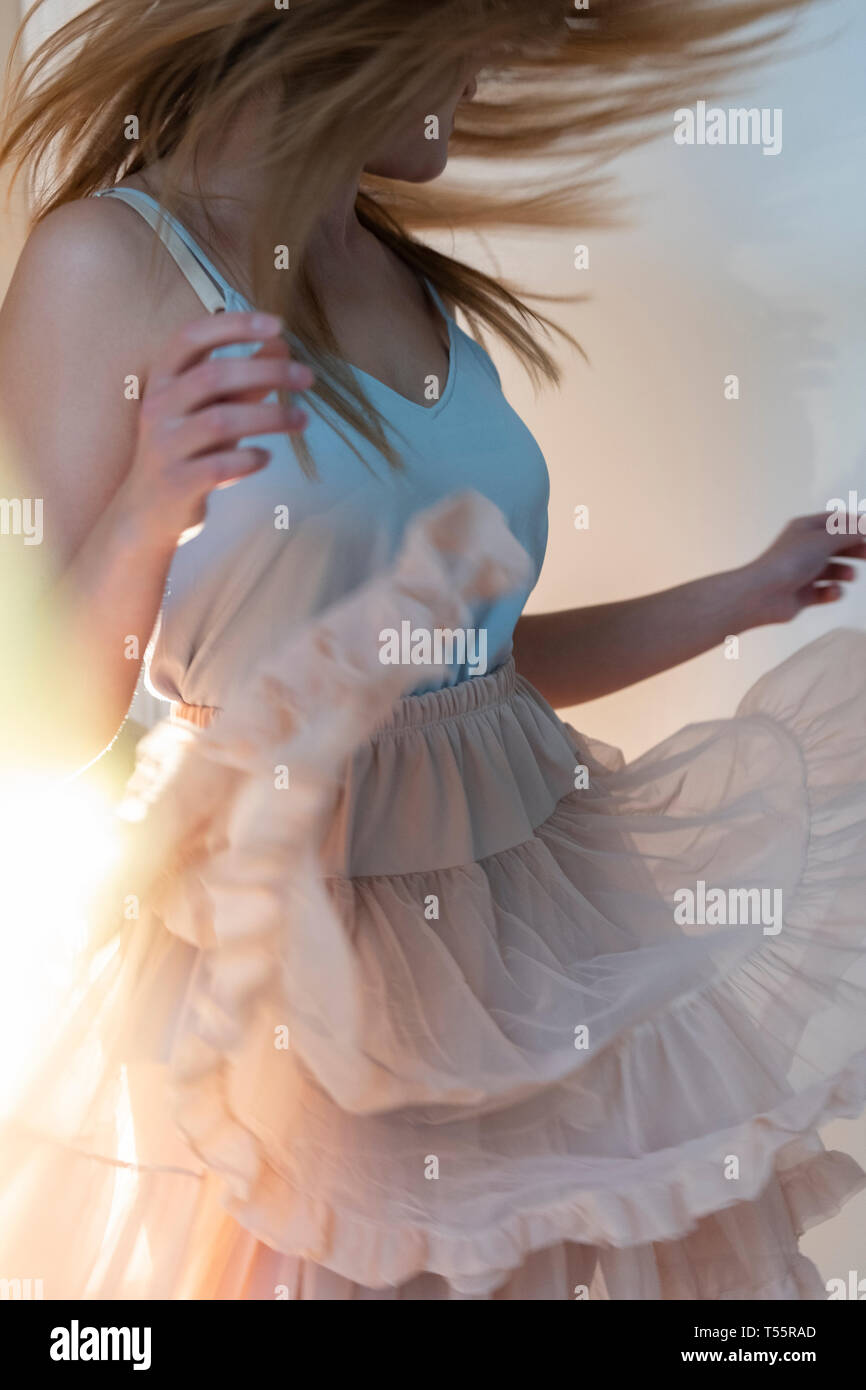 Young woman tossing her head while dancing Stock Photo