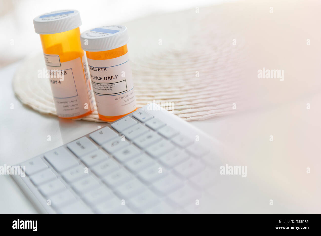 Pill bottles by computer keyboard Stock Photo Alamy