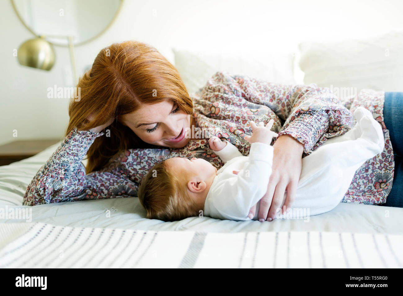 Mother lying on bed with her newborn son Stock Photo