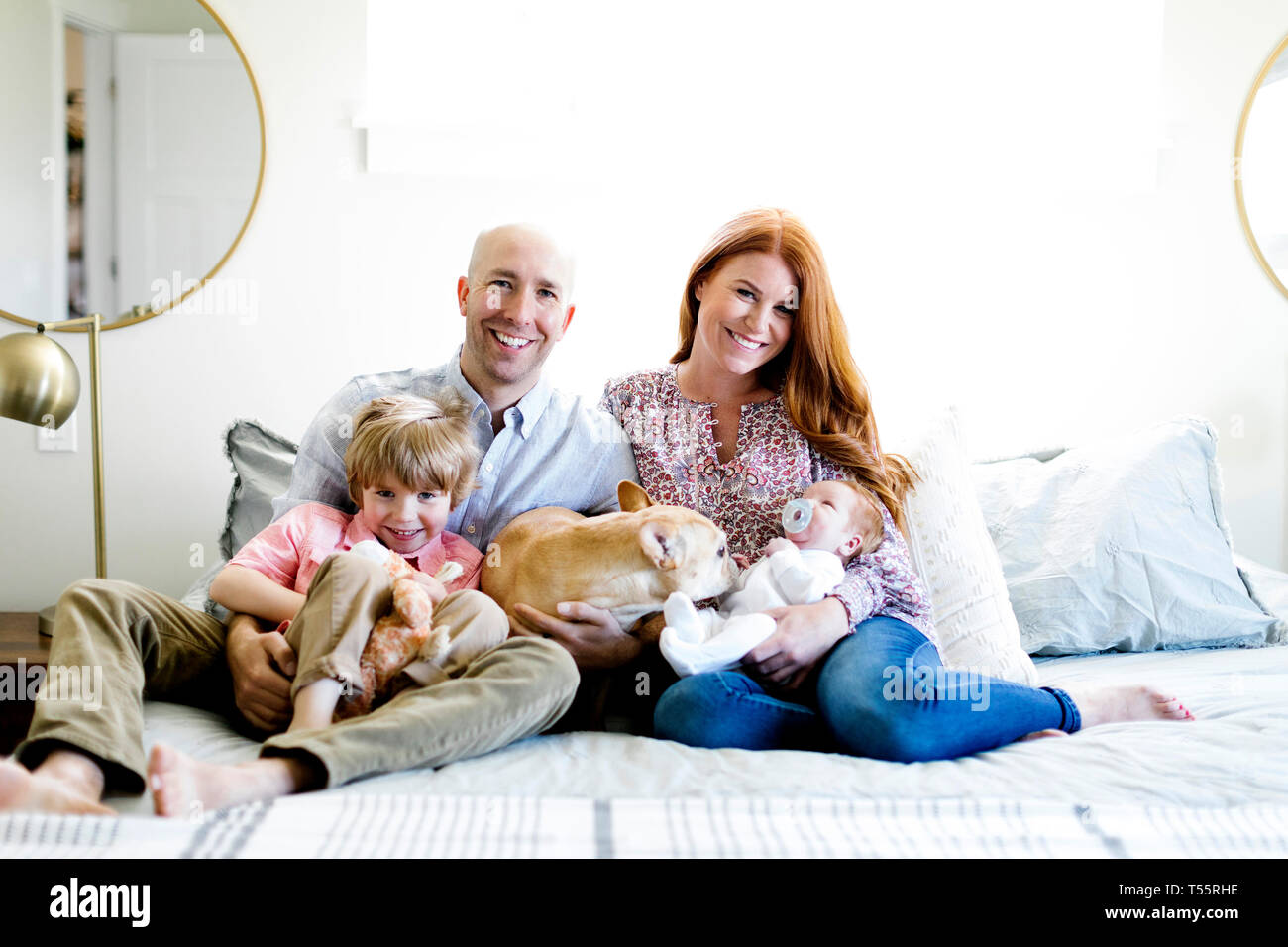 Family and their dog on bed Stock Photo