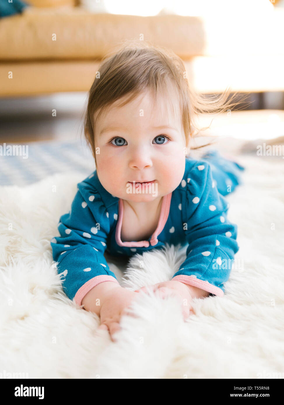 Baby girl lying on rug Stock Photo