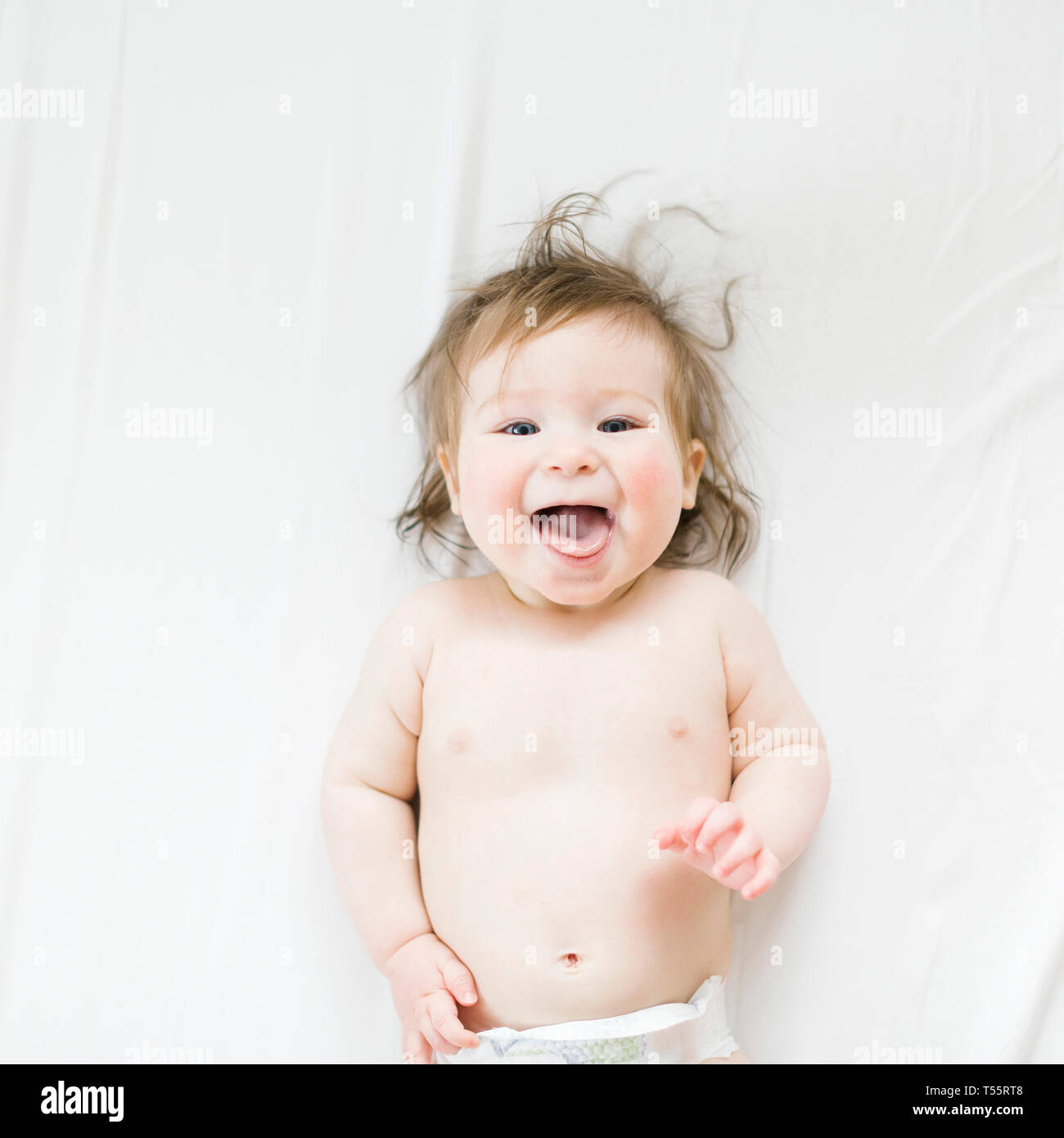 View directly above baby girl with her mouth open Stock Photo