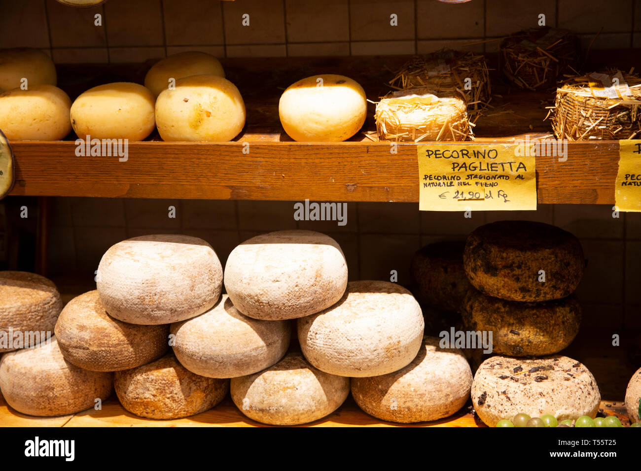 Italian cheeses and pecorino cheese in a cheesemonger shop in Pienza