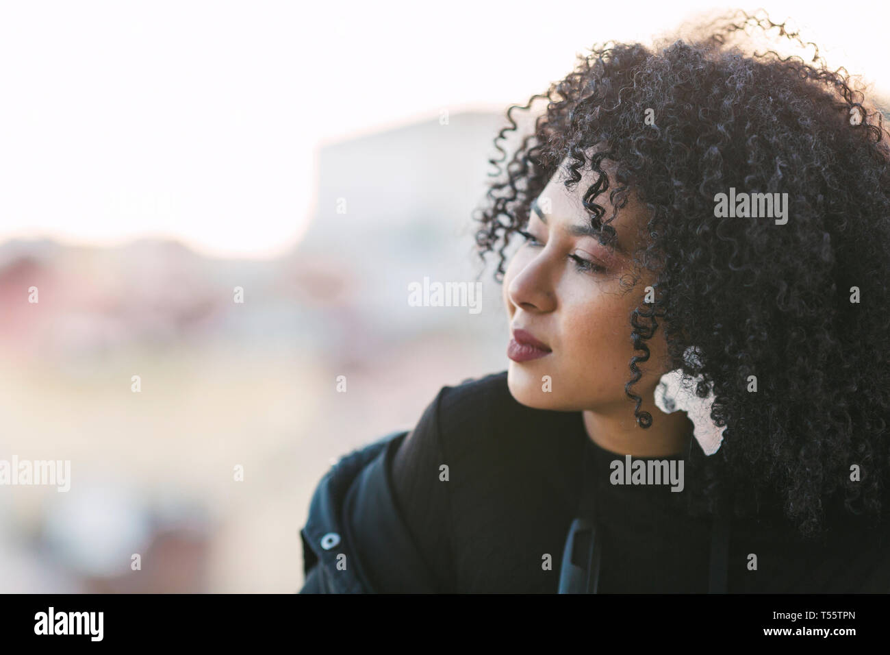 Portrait of young woman with curly black hair Stock Photo