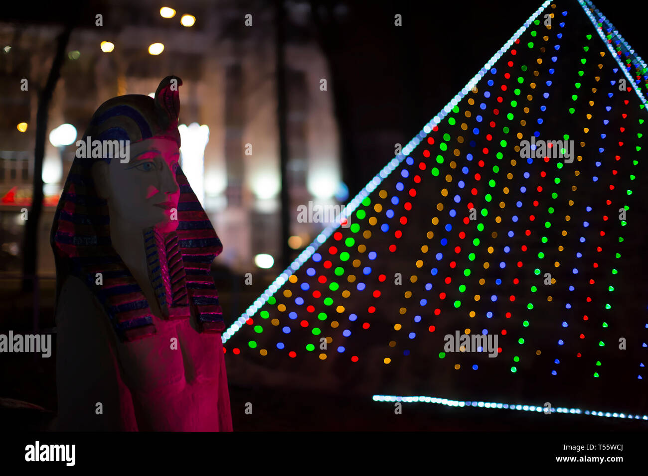 Belarus, Gomel, January 7, 2018. Miniature Egyptian statue of the pharaoh and pyramid of Cheops in New Year's lights Stock Photo