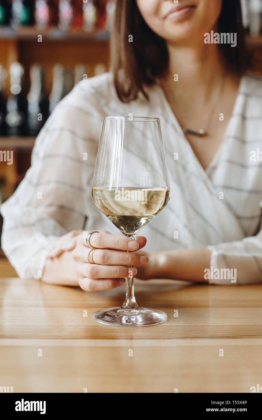 Woman holding glass of white wine Stock Photo - Alamy