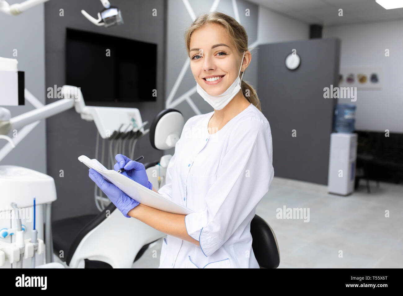 Dental assistant writing notes Stock Photo Alamy