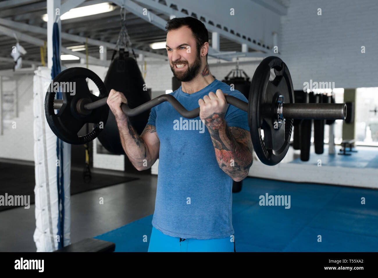 Mid adult man weight lifting in gym Stock Photo