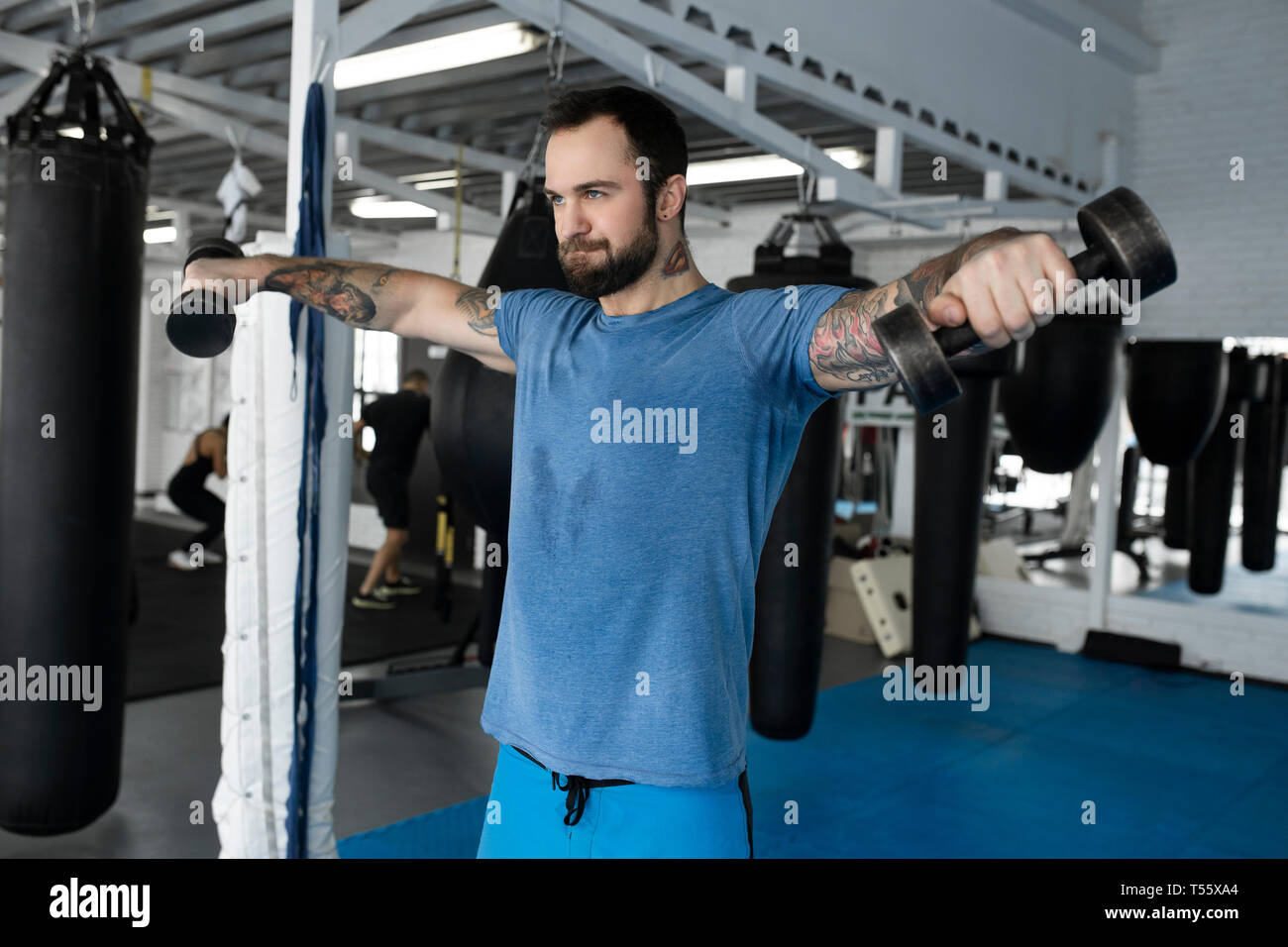 Mid adult man lifting dumbbells in gym Stock Photo