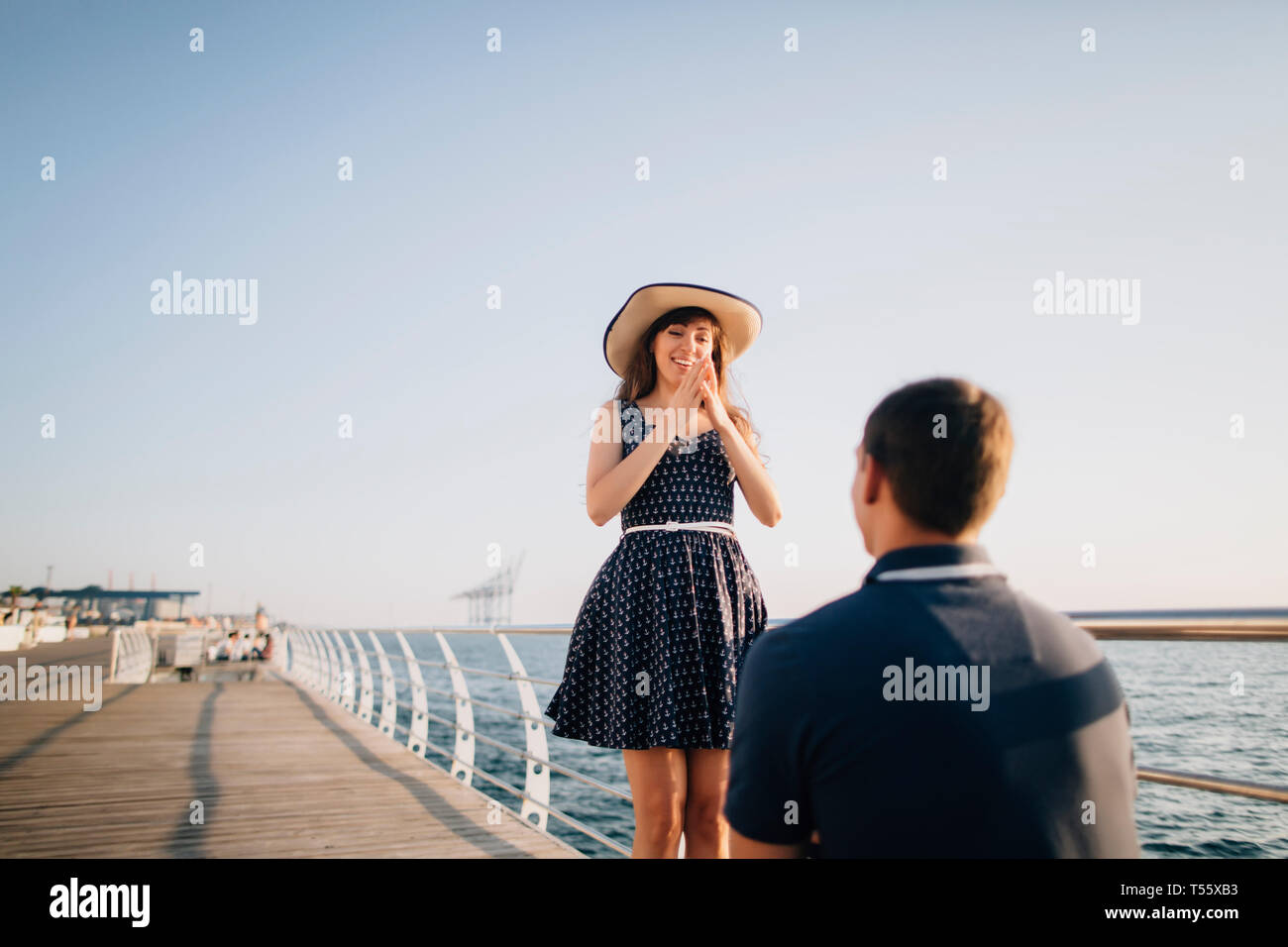 Man proposing to woman on pier Stock Photo