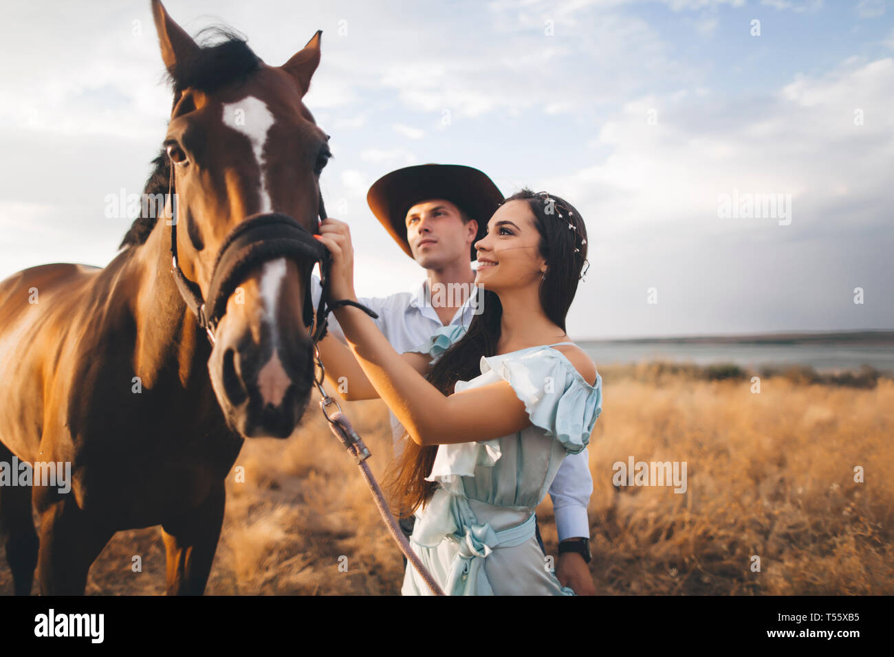 Young couple with horse in field Stock Photo
