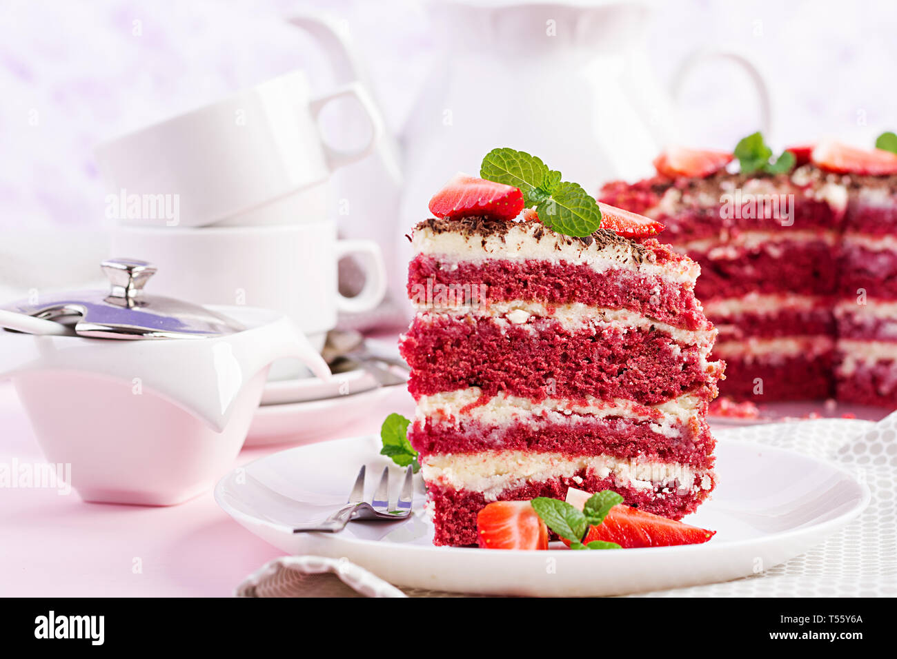 Red velvet cake on a pink background. Tea drinking. Table setting. Stock Photo