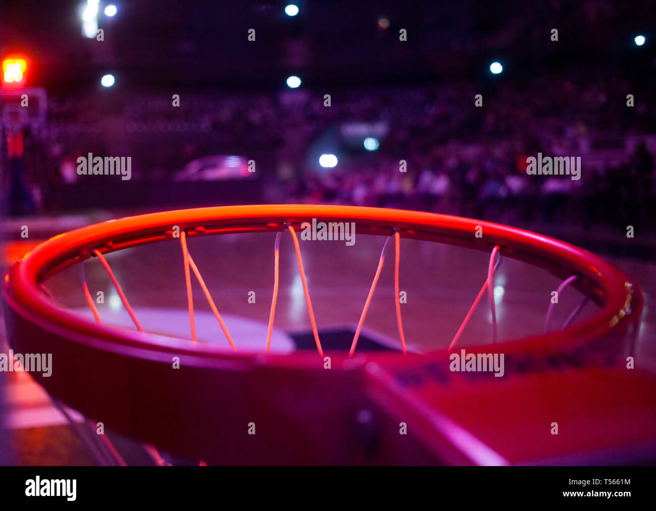 basketball hoop in red neon lights in sports arena during game