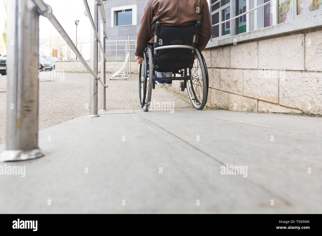 Man in a wheelchair use a wheelchair ramp Stock Photo - Alamy