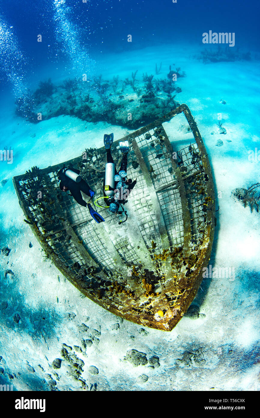 Divers explore what remains of the Thunder-dome, now an artificial reef in Turks & Caicos Islands. Stock Photo