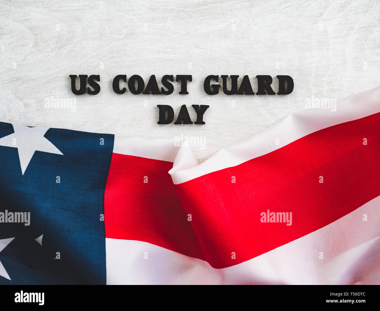 Beautiful card for US Coast Guard Day. Wooden letters with a congratulatory inscription on a white background. Close-up, top view. Congratulations for Stock Photo