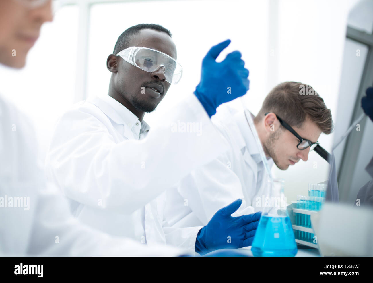 group of scientists are conducting experiments with the liquid ...