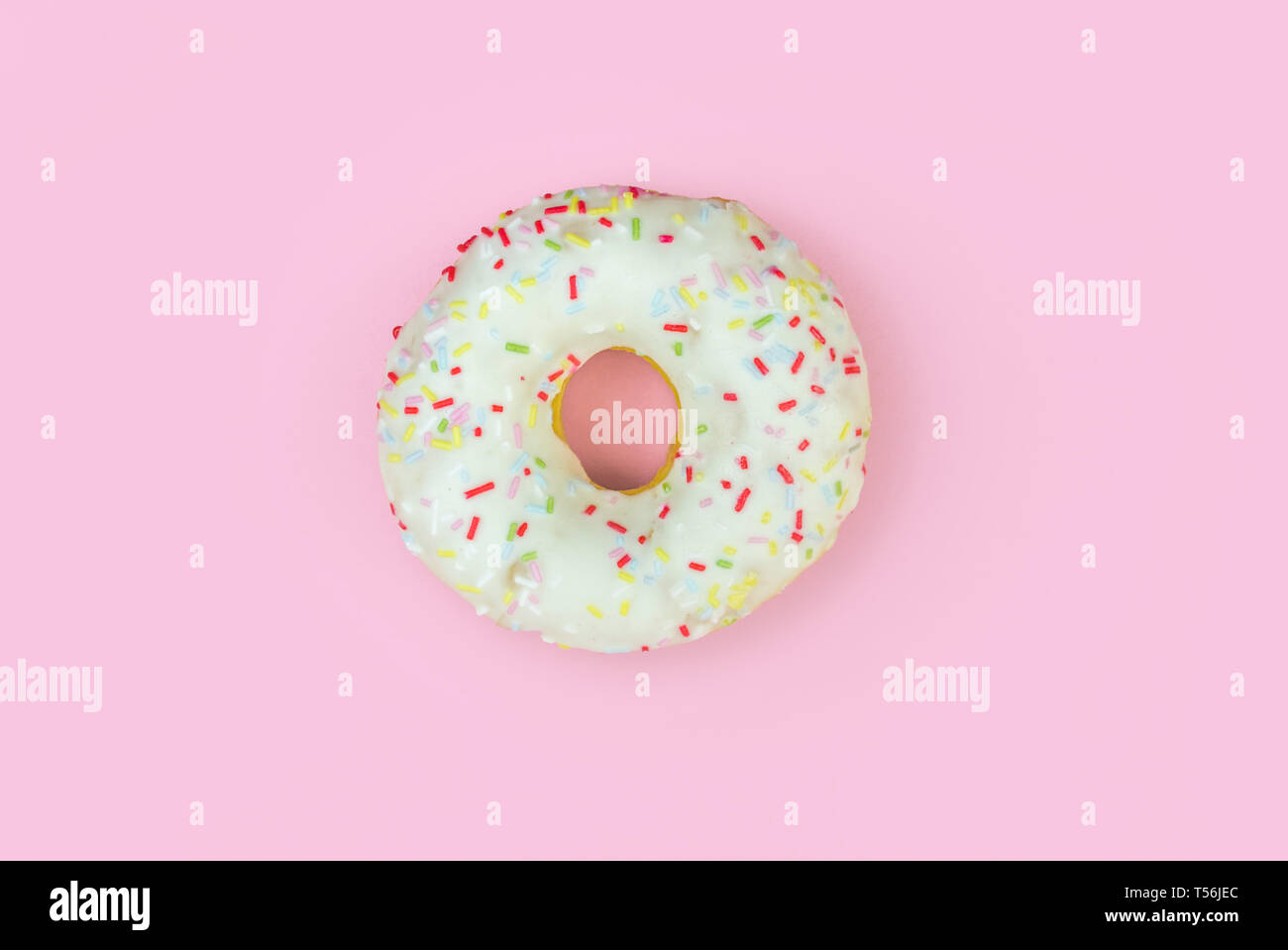 White round donut on pink background. Flat lay, top view. Stock Photo