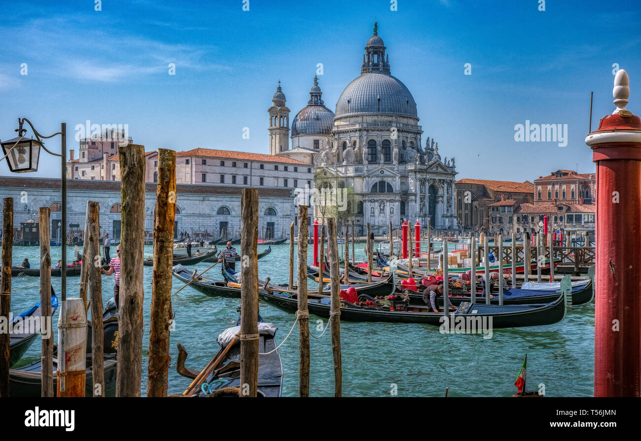 Venice, Italy - April 17 2019: Gondolas in Venice with Basilica di Santa Maria della Salute in background Stock Photo