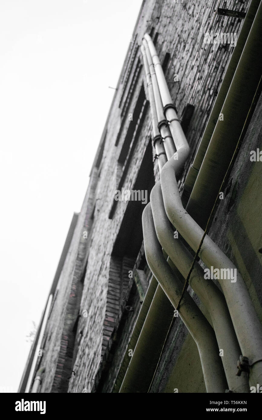 Urban industrial pipes on side of a building Stock Photo