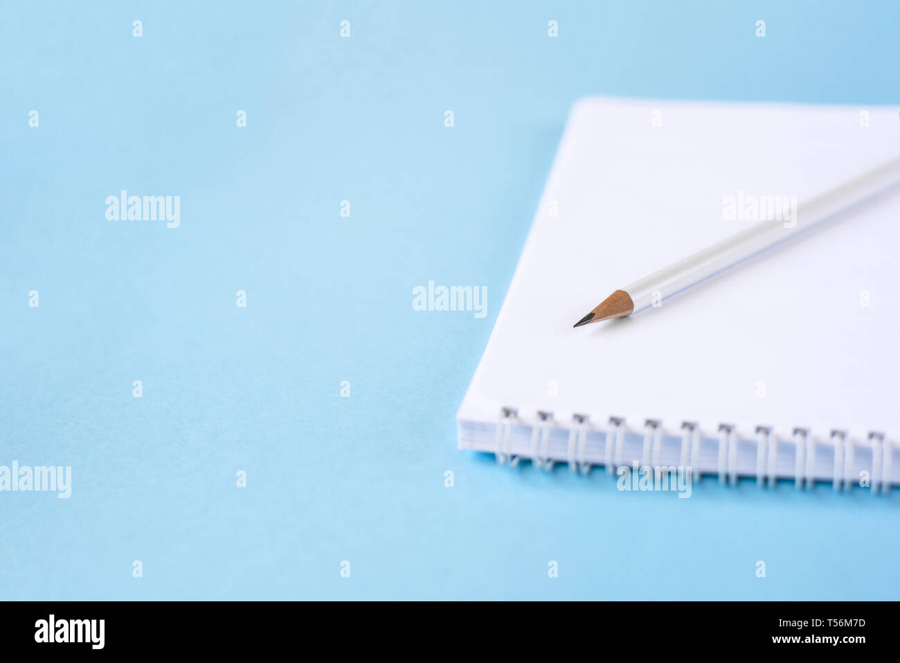 A pencil and a notebook on blue surface. Close up. Copy space for text Stock Photo