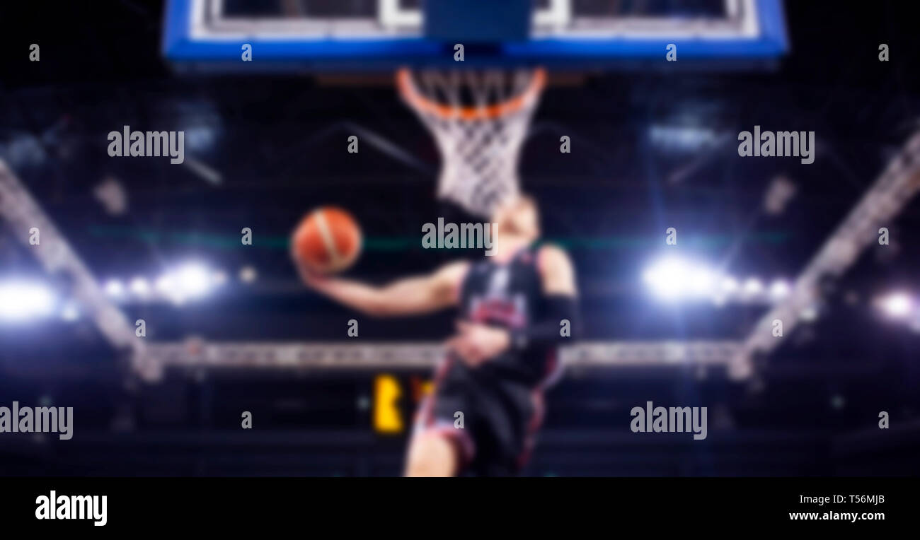 blurred image of basketball player during slam dunk - game background Stock Photo