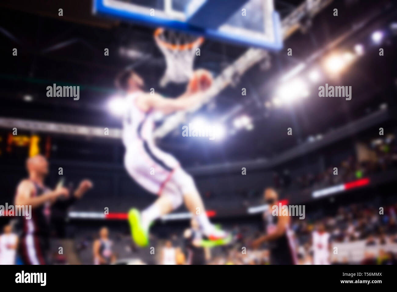 blurred image of basketball player during slam dunk - game background Stock Photo